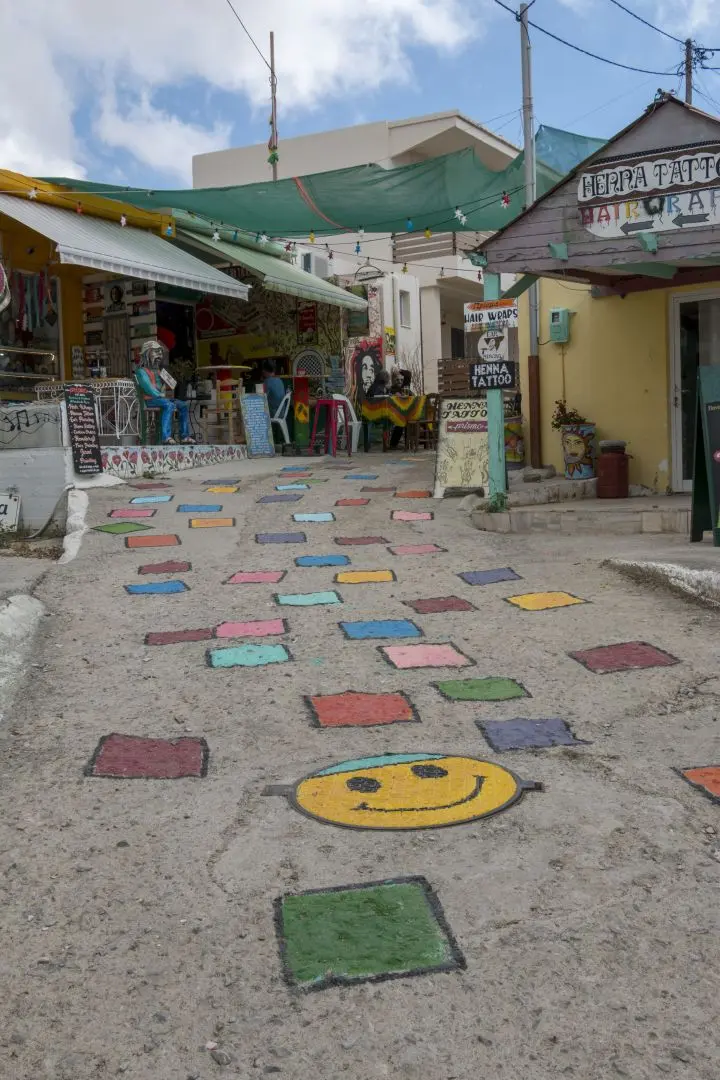 A smiley face and coloured squares on the floor of a street in Matala