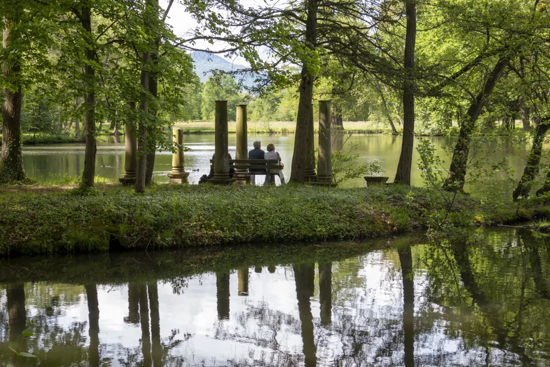 A couple rests on a bench on the Ile des Demoiselles in Schoppenwihr park.